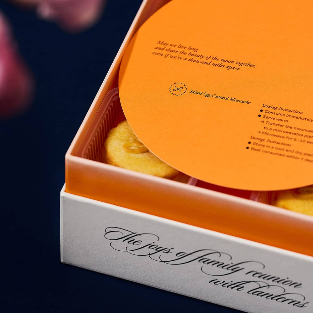
                
                    Load image into Gallery viewer, A 2022 mooncake gift set in gradient orange with salted egg custard mooncakes inside and an orange info card on top of it
                
            