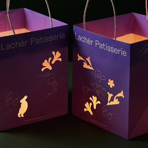 2 lighted paper bag lanterns with illustrations of the traditions of Mid Autumn.