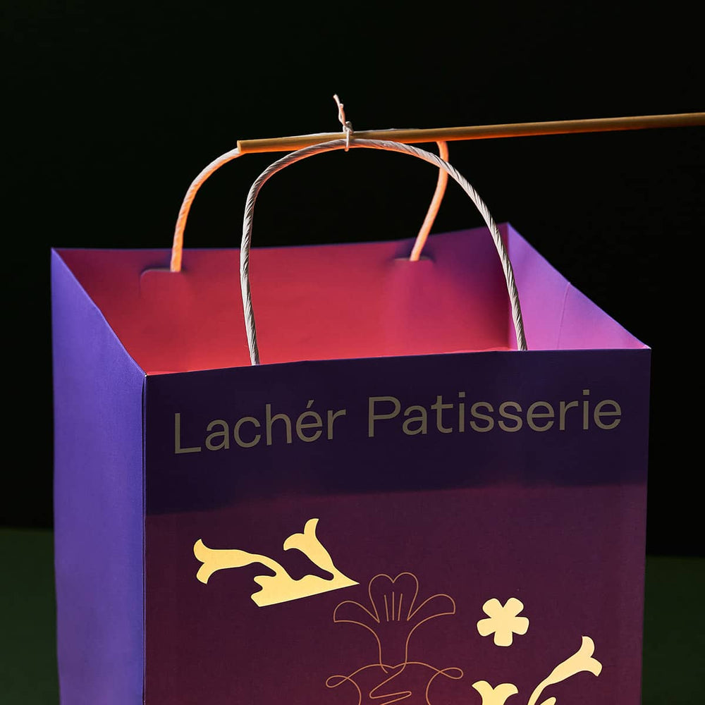 
                
                    Load image into Gallery viewer, A close up of a stick tied to the handles of a lighted paper bag lantern.
                
            