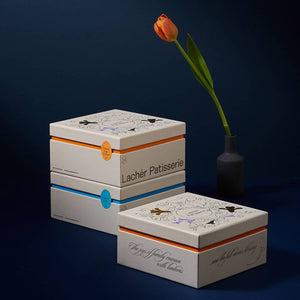 3 boxes of 2022 mooncake gift sets with a flower in a vase beside it.