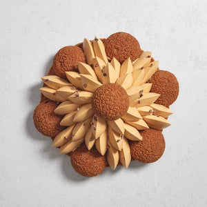 The top view of a Salted Caramel Saint-Honore cake with 6 choux puffs and a pyramid-like salted caramel piping topped with another choux puff.